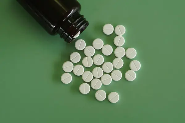 Pilulky Kontejnerem Zeleném Pozadí — Stock fotografie
