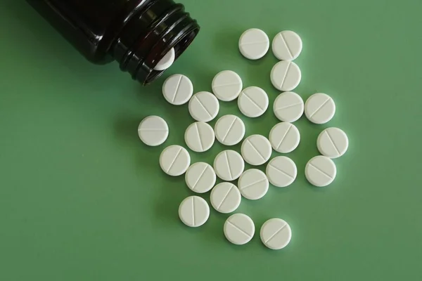 Pillole Con Contenitore Sullo Sfondo Verde Fotografia Stock