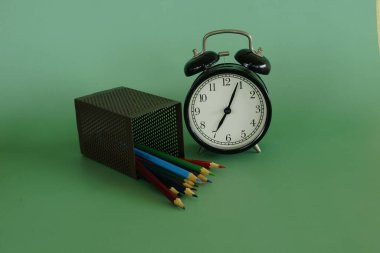 Masadaki renkli kalemleri ve çalar saati kapat.