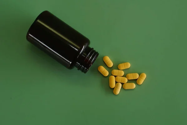 Pilulky Kontejnerem Zeleném Pozadí — Stock fotografie