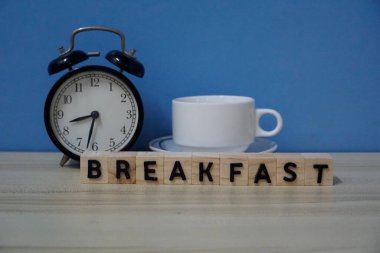 Çalar saat ve masada beyaz bir bardak. Kahvaltı konsepti 