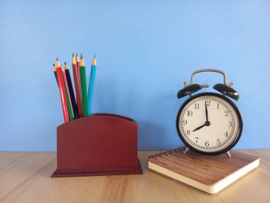 Masada kalemler olan çalar saat.