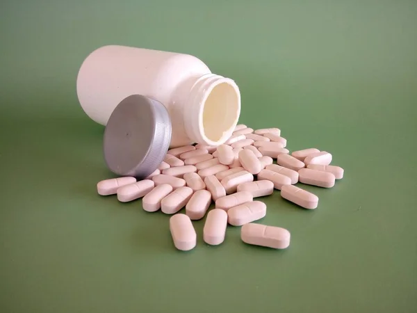 Pílulas Com Recipiente Contra Fundo Verde — Fotografia de Stock