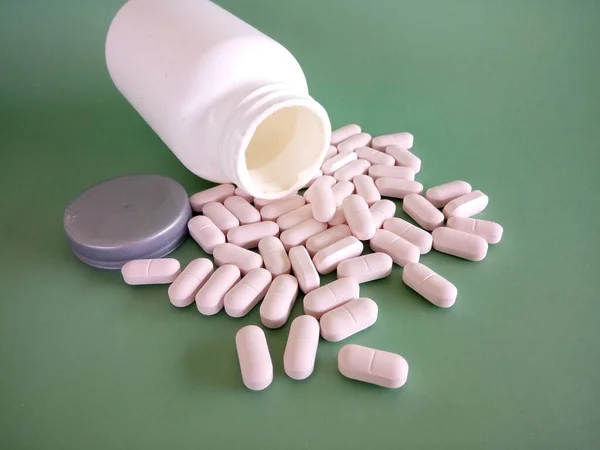 Pillen Met Container Tegen Groene Achtergrond — Stockfoto