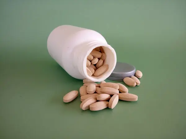 Tabletták Konténerrel Zöld Háttér Ellen Stock Fotó