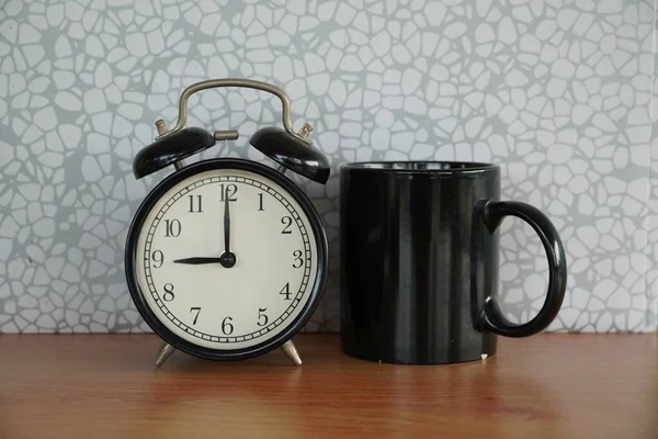 目覚まし時計とテーブルのマグカップ — ストック写真