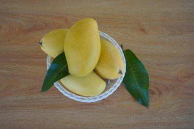 Ahşap arka planda doğranmış mango meyvesi