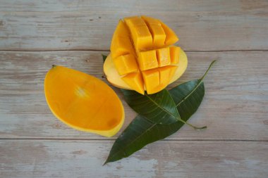 Ahşap arka planda doğranmış mango meyvesi