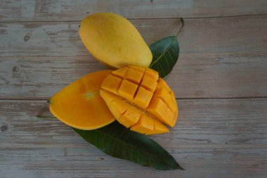 Ahşap arka planda doğranmış mango meyvesi