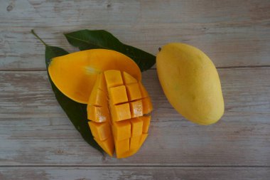 Ahşap arka planda doğranmış mango meyvesi