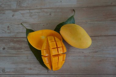 Ahşap arka planda doğranmış mango meyvesi