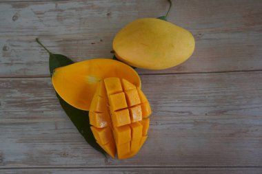 Ahşap arka planda doğranmış mango meyvesi