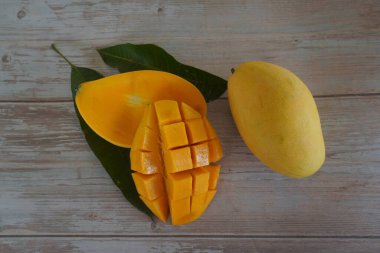 Ahşap arka planda doğranmış mango meyvesi