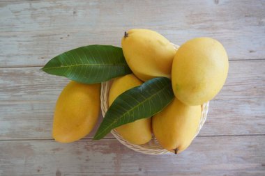 Ahşap arka planda mango meyveleri