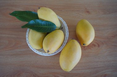 Ahşap arka planda mango meyveleri