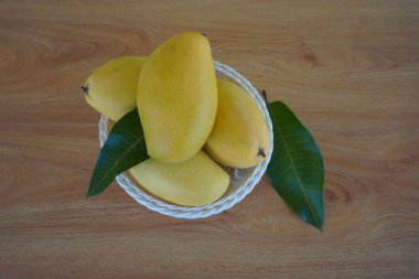 Ahşap arka planda mango meyveleri