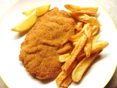 Patates kızartması ve limon dilimleri soslu pirzola.