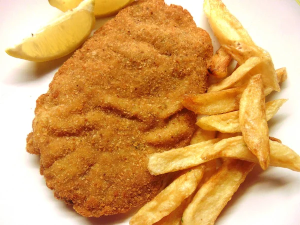 breaded cutlets with french fries and lemon slices as dressing