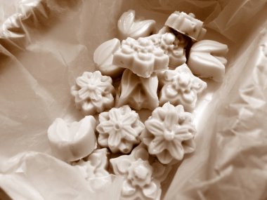 Sepya tonlarında beyaz çikolata bombaları içeren küçük bir kutu.