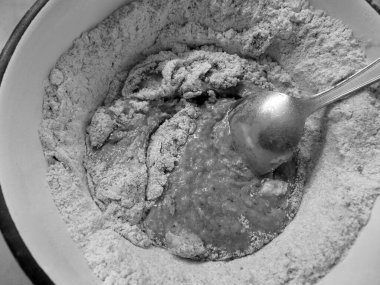 adding ingredients for making cocoa flavoured dough, in black and white