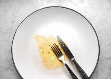 İçinde yiyecek kalıntıları olan boş bir tabak.