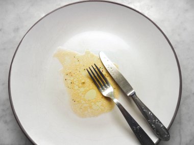 İçinde yiyecek kalıntıları olan boş bir tabak.