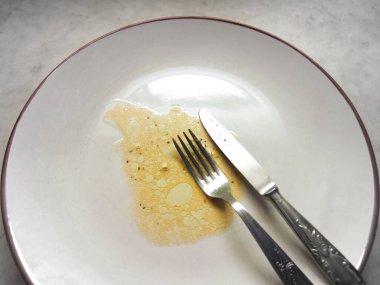 İçinde yiyecek kalıntıları olan boş bir tabak.