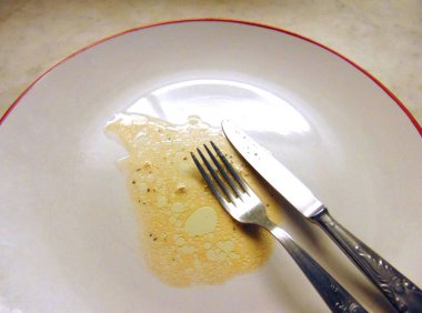 İçinde yiyecek kalıntıları olan boş bir tabak.