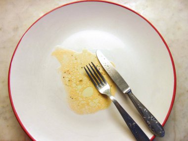 İçinde yiyecek kalıntıları olan boş bir tabak.