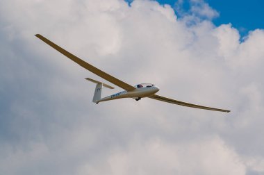 Beyaz bir planör bulutlu gökyüzünde süzülüyor..