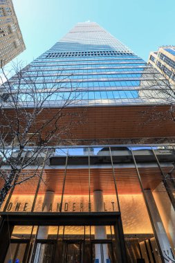 New York City 'deki One Vanderbilt gökdeleninin alçak açılı görüntüsü parlak mavi gökyüzüne karşı parlak cam perdesi ve yükselen mimari çizgileri sergiliyor. Dramatik perspektif kuleleri vurguluyor modern tasarım ve etkileyici dikey ölçek.