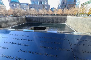 Manhattan, New York 'taki 9 / 11 Memorial ve One World Trade Center manzarası. Yansıtıcı havuzlar 11 Eylül 2001 'de kaybedilen hayatları onurlandırırken yükselen kule ve çevresindeki şehir manzarası Manhattan' ın direnç ve kentsel enerjisini sembolize ediyor..