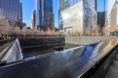 Manhattan, New York 'taki 9 / 11 Memorial ve One World Trade Center manzarası. Yansıtıcı havuzlar 11 Eylül 2001 'de kaybedilen hayatları onurlandırırken yükselen kule ve çevresindeki şehir manzarası Manhattan' ın direnç ve kentsel enerjisini sembolize ediyor..