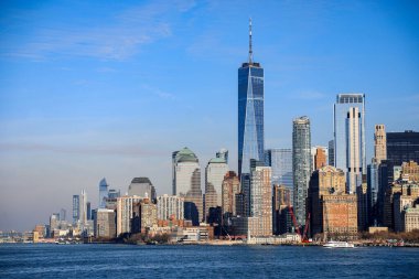 Limandan New York şehrinin panoramik manzarası, ikonik gökdelenler, hareketli sahil manzarası ve Doğu Nehri 'nin parıldayan suları. Sahne Manhattan 'ın enerji ve mimari çeşitliliğini sudan yansıtıyor..