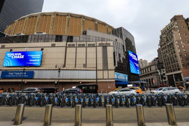 Kışın hareketli bir New York sokak sahnesi, karla kaplı sokaklar, yayalar paltoya sarılı, sarı taksiler, ve yüksek gökdelenler. Sahne, Manhattan 'ın canlı enerjisini soğuk, şenlikli ve kış atmosferinin ortasında yakalıyor..