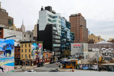 New York 'taki High Line' ın manzaralı manzarası, kalabalık Manhattan sokaklarına bakan modern apartmanlar, klasik binalar ve şehir trafiği. High Line 'ın şehir yeşilliği etrafındaki ufuk çizgisiyle güzel bir tezat oluşturuyor..