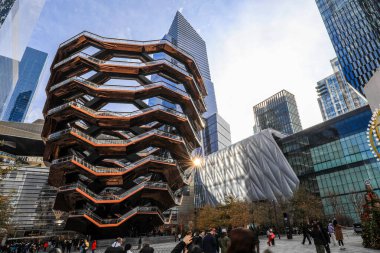 Hudson Yards, New York 'ta The Vessel' in çarpıcı mimari görüntüsü. Birbirine bağlı merdivenlerin bu bal peteğine benzer yapısı günışığını yansıtan ve Manhattan 'da çağdaş kentsel tasarımı gözler önüne seren modern ufuk çizgisine karşı yükselir..
