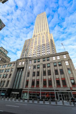 Empire State Binası 'nın New York' ta açık mavi bir gökyüzüne uzanan alçak açılı görüntüsü. Sanat deco ikonu çerçeveye hükmediyor, hırsı, mimariyi ve Manhattan siluetinin ebedi ruhunu simgeliyor..
