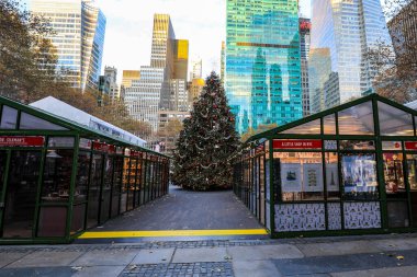 New York 'taki Bryant Park Noel Pazarı' nın kalbinde çok güzel dekore edilmiş bir Noel ağacı duruyor. Parıldayan ışıklar ve şenlikli süsler, pazar tezgahları ve kış kenti zeminiyle çevrili sıcak bir tatil atmosferi yaratıyor..
