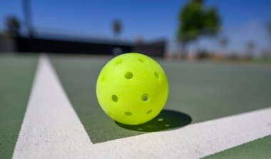 Sahada beyaz çizgileri olan bir topa odaklan. Pickleball sporu Amerika 'nın en hızlı büyüyen sporu haline geldi..