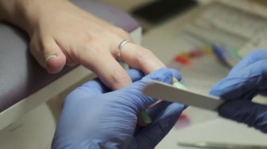 Çivi şeklinde manikürcü dosyaları. Tırnak sanatları ustası tırnak törpüsü ile çivileri şekillendirir, tırnak bakımını kapatır..