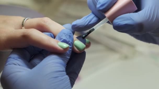 手与修指甲 专业的美容师用胶水和刷子刷指甲 洗澡水概念特写 — 图库视频影像