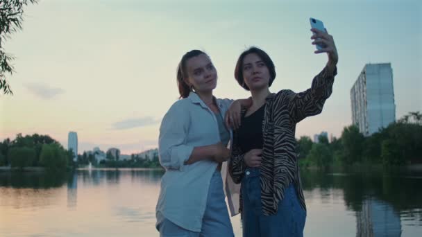 Две Улыбающиеся Девушки Делают Селфи Озере Портрет Веселых Девушек Фотографирующих — стоковое видео