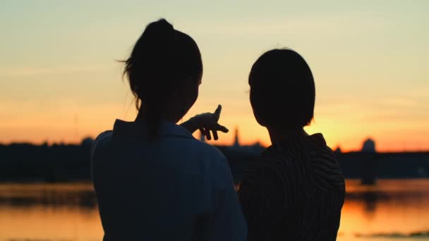 Две Женщины Пляже Закате Девушка Указывает Вечернее Небо Люди Силуэты — стоковое видео