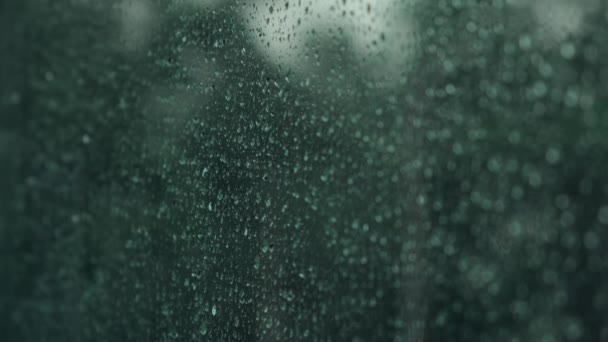 雨滴落在窗玻璃表面 透明玻璃上的水滴 风暴天气的概念 雨夜雨窗外的绿树 高质量的4K镜头 — 图库视频影像