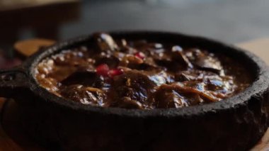 Kızartma tavasında leziz et. Restoranda taze sebzeli sulu domuz eti ve orijinal servis yemekleri var. Geleneksel Gürcü mutfağı. Yüksek kalite 4k görüntü