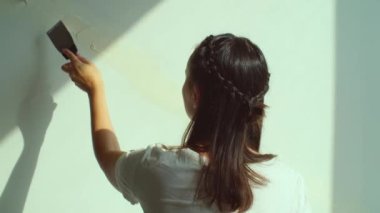 Duvara alçı yapıştıran bir kadın. Ev tadilatı, kadın işçi dikiz aynası. Bitirici işler, ev dekorasyonu konsepti, yavaş çekim. Yüksek kalite 4k görüntü