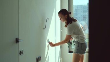 Duvara alçı yapıştıran bir kadın. Bitiş işleri, DIY evlerinin yenilenmesi, ev dekorasyonu konsepti. Ağır çekim. Yüksek kalite 4k görüntü