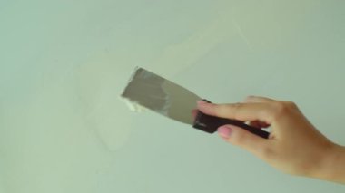 Duvara spatula yapıştıran kadın. Eklemlerin macununu tamamlamak için sıva yapan sıva ustası. DIY ev yenileme, ev dekorasyonu konsepti. Ağır çekim. Yüksek kalite 4k görüntü