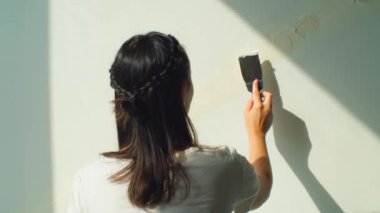 Duvara alçı yapıştıran bir kadın. Ev tadilatı, kadın işçi dikiz aynası. Bitiş işleri, ev dekorasyonu konsepti gibi eklemlerin macunu. Ağır çekim. Yüksek kalite 4k görüntü